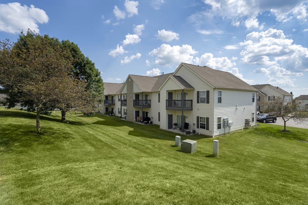 A white house with a green lawn in front of it.