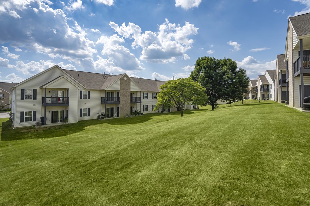 A row of houses with a green lawn in front.
