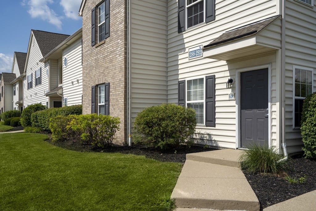 A white house with a grey door and windows.