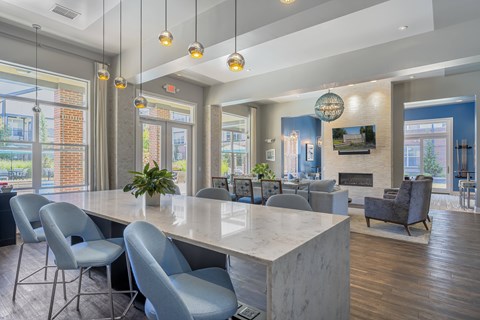 A modern dining room with a long table and grey chairs.