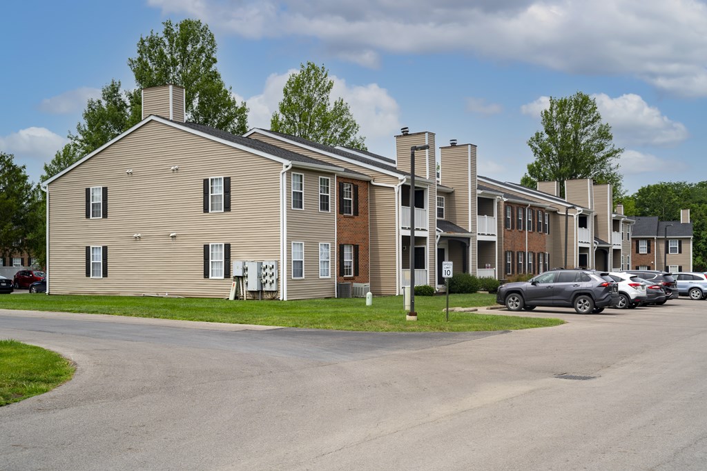 A row of houses with cars parked in front.