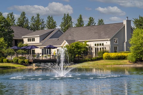 A house with a water fountain in front of it.