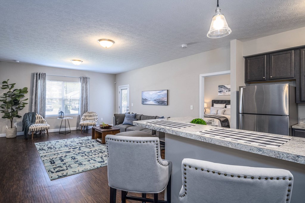 a kitchen and living room with a counter top and a refrigerator