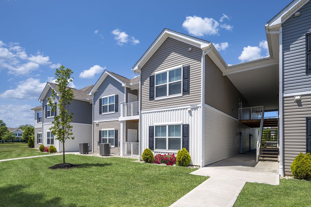 the outlook of a row of houses with grass and a sidewalk