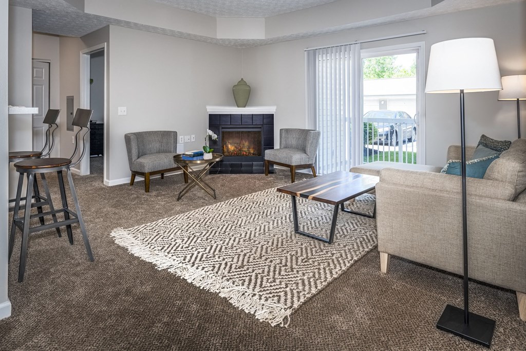 a living room with a couch and chairs and a fireplace