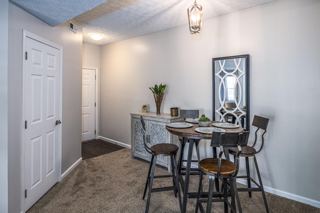 a dining room with a table and chairs and a mirror