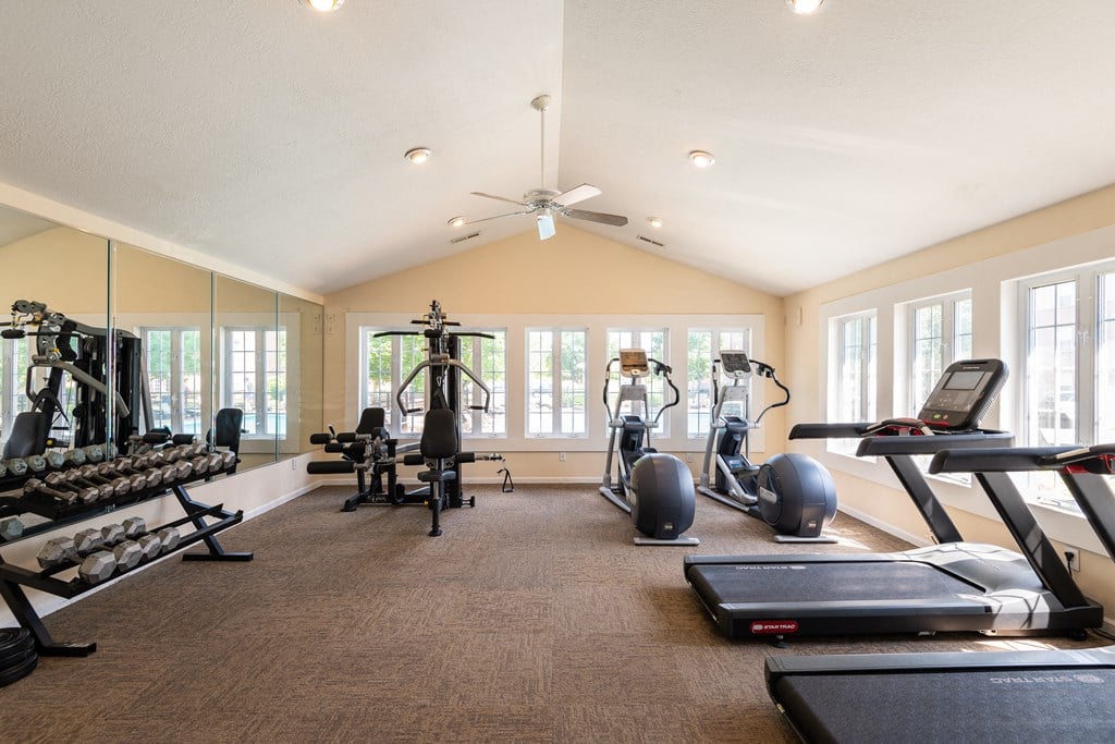 On-site fitness center with various workout machines and a ceiling fan