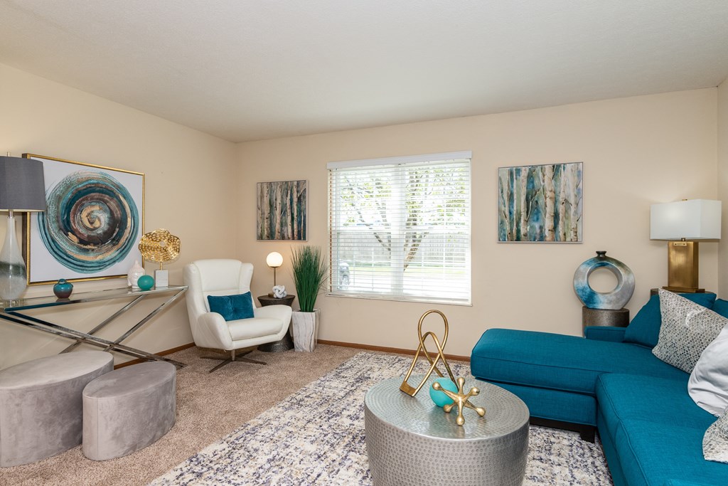 a living room with a blue couch and white chair