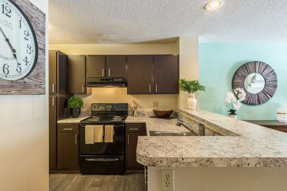 One-Bedroom Apartments in Dublin, OH - Britton Woods - Kitchen with Energy Efficient Appliances, Espresso Cabinets, Granite Counters, Wood-Style Flooring, and Breakfast Bar