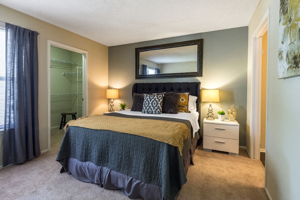 One BR Apartments in Dublin OH - Britton Woods - Bedroom with Bed, Nightstands, Lamps, Oversized Closet, and Attached Bathroom.