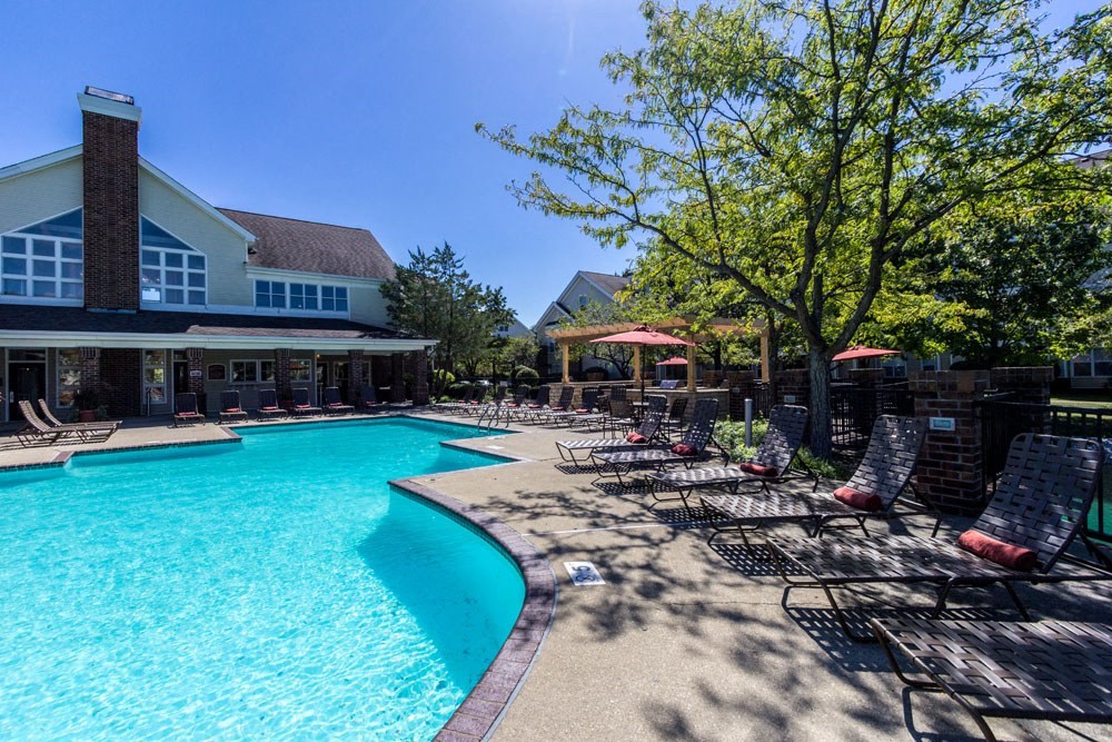 a resort style pool with lounge chairs and a building in the background
