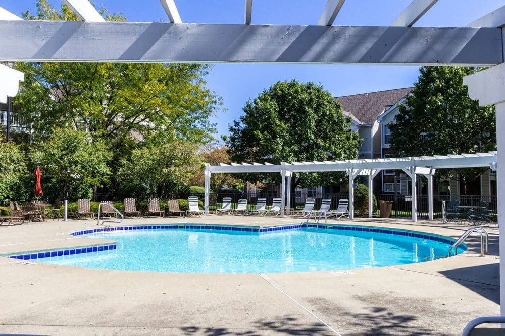 Dog-Friendly Apartments in Dublin OH - Britton Woods - Sparkling Pool Surrounded By Lounge Chairs, Tables, Umbrellas, and Pergolas.