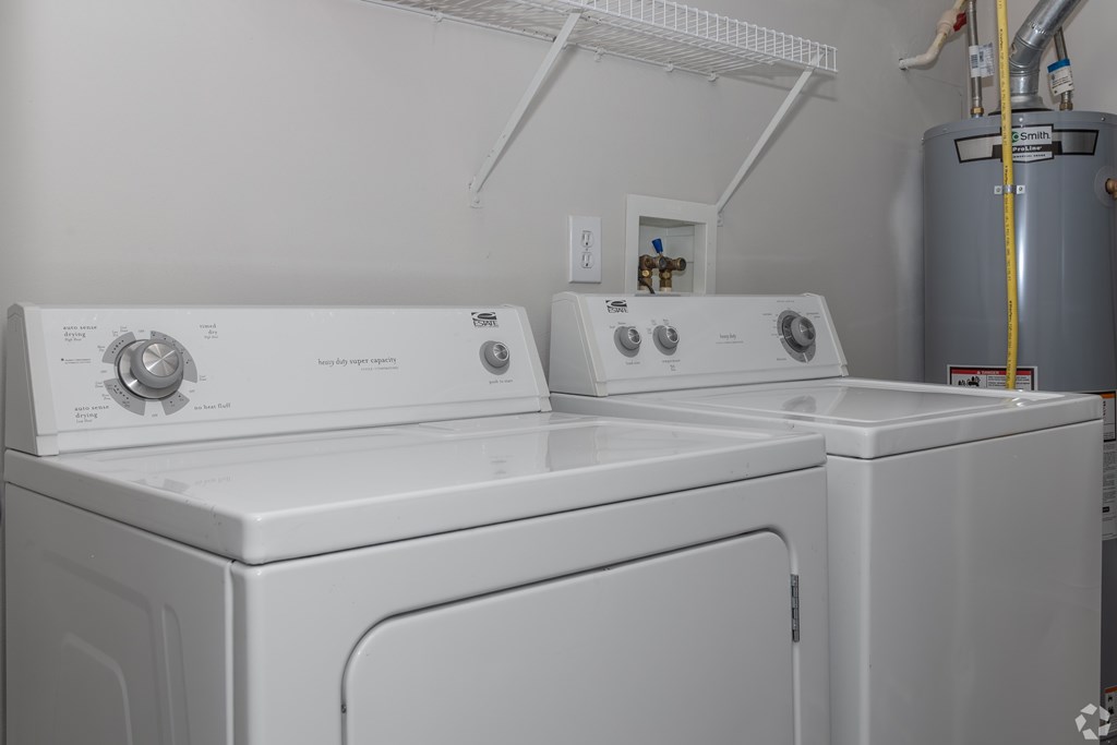 A white dryer and washer are sitting next to each other.