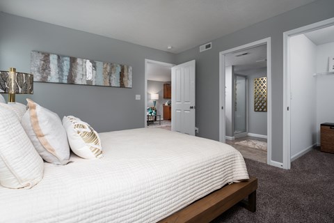 Modern bedroom with gray walls and a large white bed for a calm, neutral palette