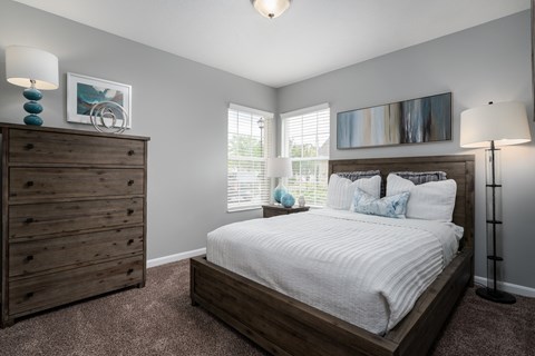 Cozy bedroom setup with a bed, dresser, and neutral decor at Carson Farms
