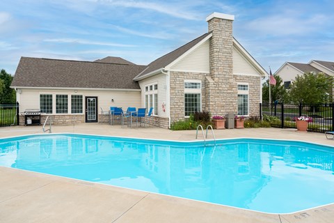 Delaware, OH Apartments Near Tanger Outlets - Carson Farms - Swimming Pool Surrounded By Patio Furniture, BBQ Area, and Lush Landscaping