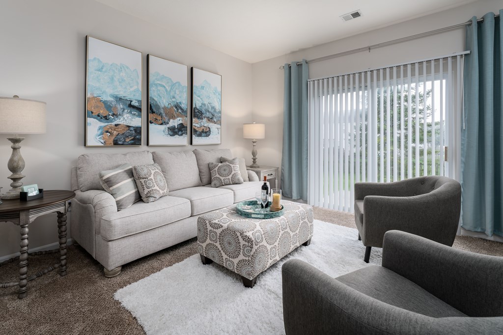 A living room with a grey couch, a coffee table, and a painting on the wall.