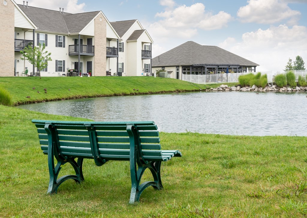 Apartments for Rent in Pataskala, OH - Catalina Club - Large Pond Surrounded By Lush Green Grass and a Bench.