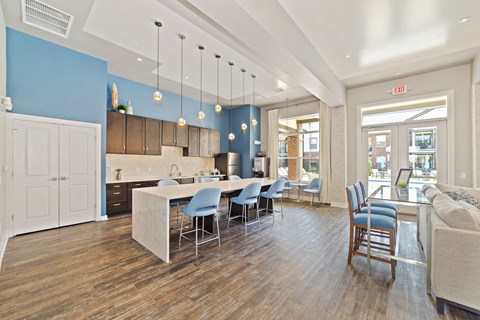 a kitchen with blue walls and a white island with blue chairs