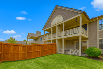 A house with a brown fence and a green lawn.