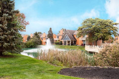 A fountain pond surrounded by trees and landscaped grounds.