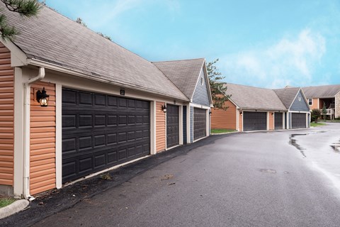 Exterior view of Fairway Lakes featuring black garage doors and a paved driveway.