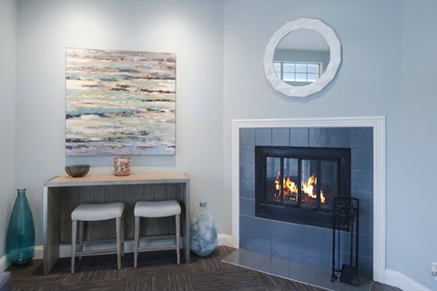 a living room with a fireplace and a table with two stools