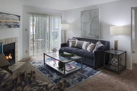 a living room with a couch and a coffee table and a fireplace