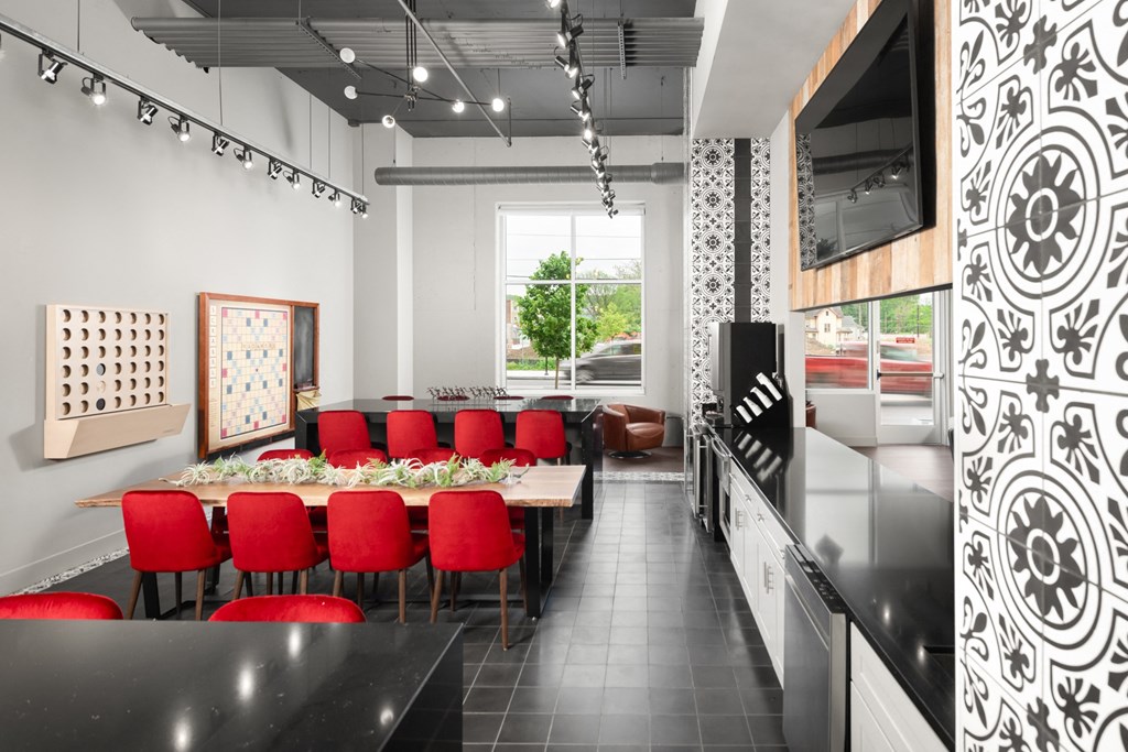 Co-working lounge with booth tables next to a beige couch, and light fixtures,