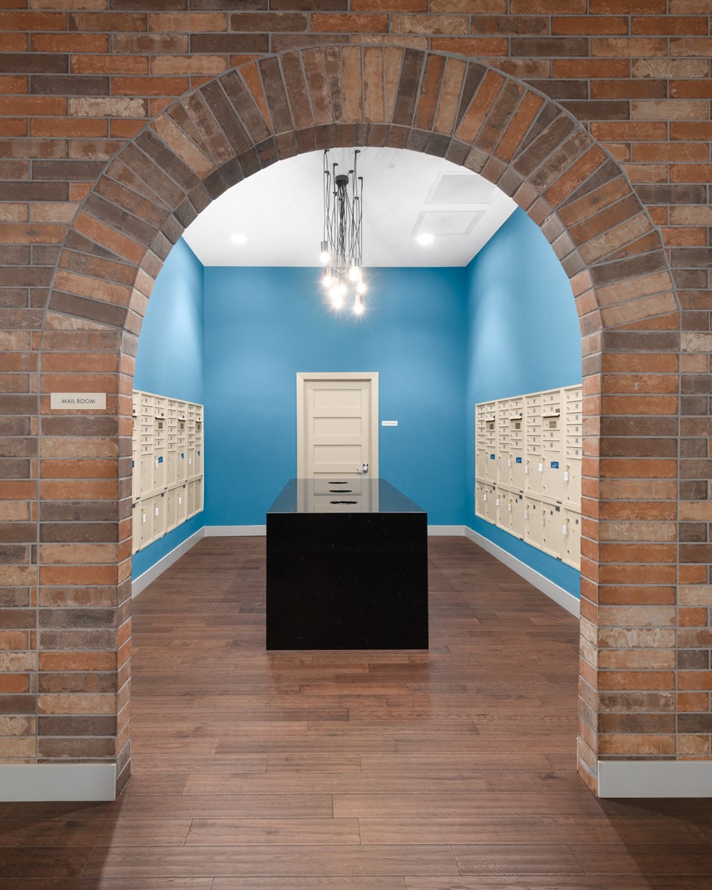 A private mail and delivery room with white lockers on a blue wall.