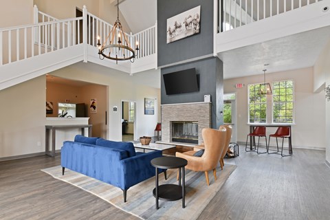 A living room with a blue couch and a fireplace.