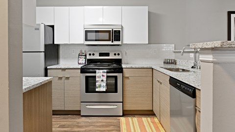 A modern kitchen with a stove top oven and microwave above it.