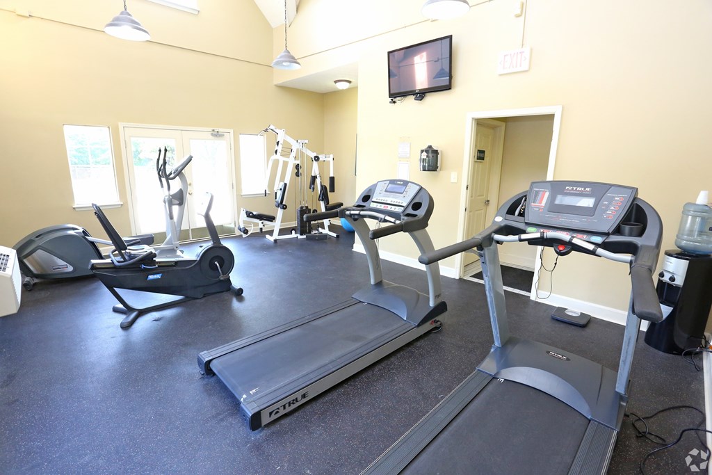 A gym with treadmills, elliptical machines, and other exercise equipment.