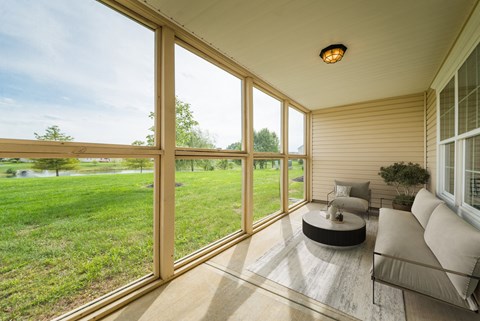 Outdoor screened in seating area with views of scenic landscaping.