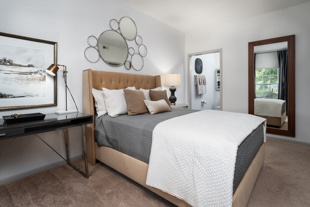 a bedroom with a bed and a desk in a room