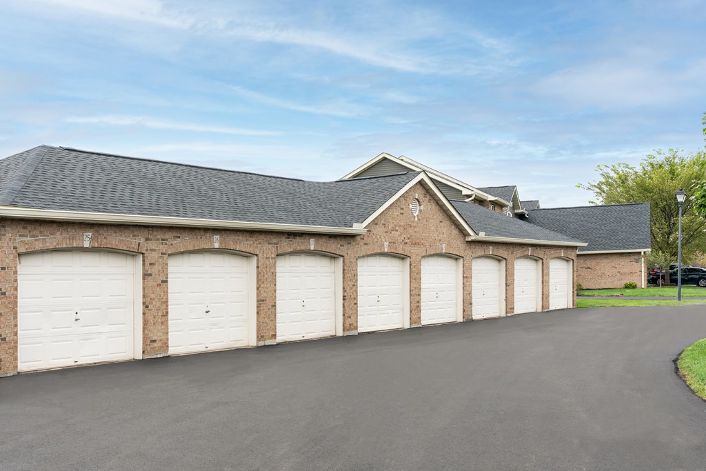 a row of three garage doors on a brick building