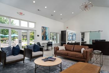 A living room with a brown couch, a coffee table, and a large window.