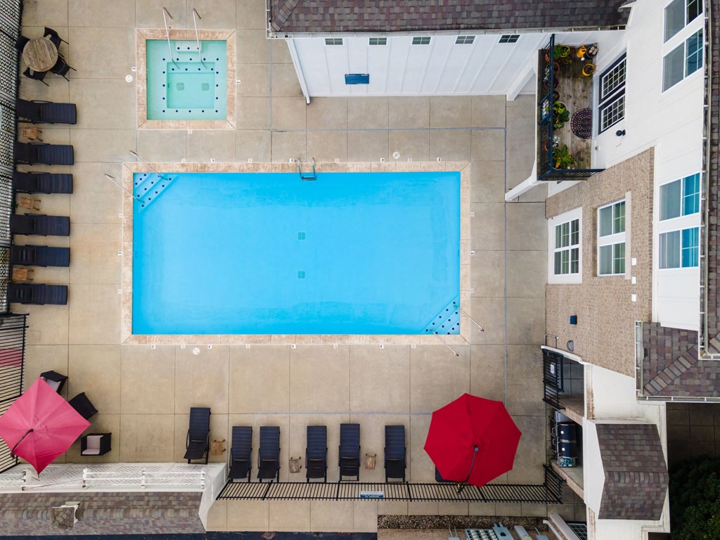 an overhead view of a pool and umbrellas on the side of a building