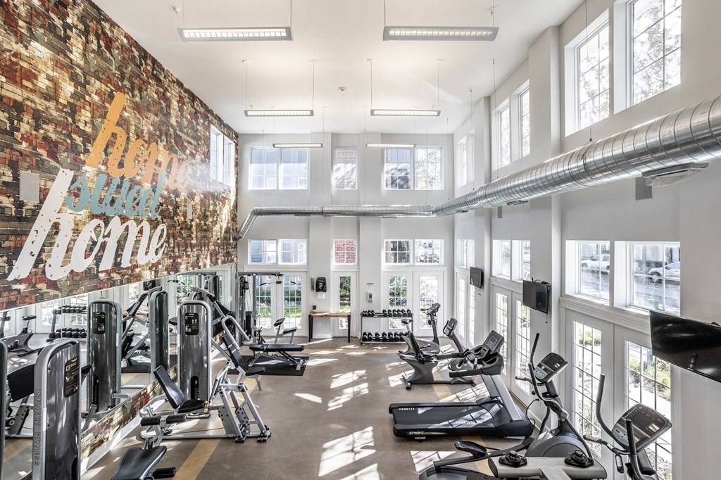 A gym with a brick wall and a variety of exercise equipment.