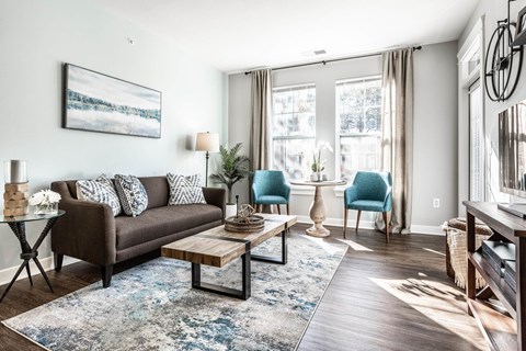 A living room with a brown couch, a coffee table, and a painting on the wall.