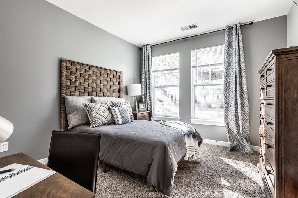 A bedroom with a bed, desk, and chair.