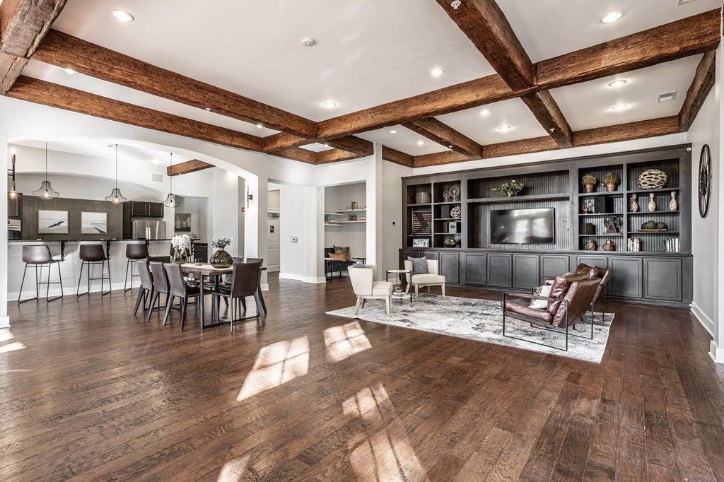 A spacious living room with wooden floors and a high ceiling.