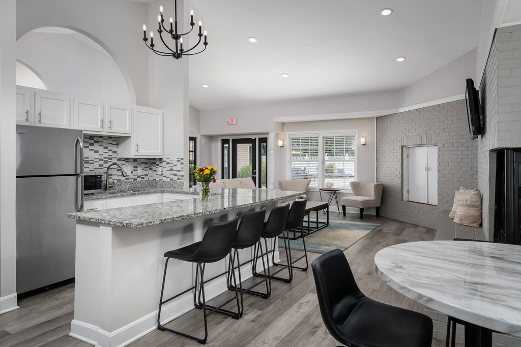 a kitchen with a large island with a breakfast bar and a living room in the background