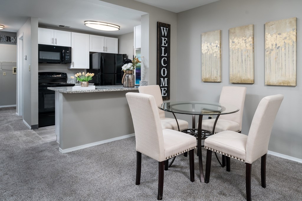 a dining area with a glass table and white chairs