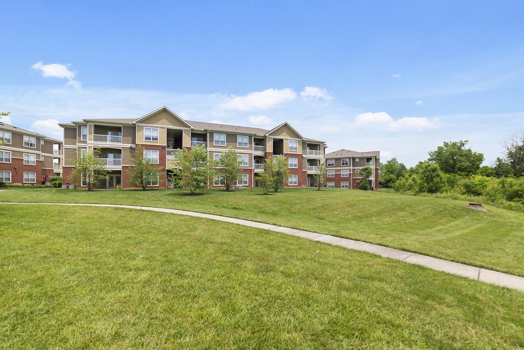 Florence, KY Apartments - Trellises - Apartment Building Exterior with Lush Green Grass and Pathways