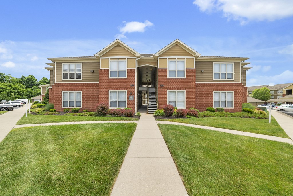 a large brick house with a sidewalk leading to the front door