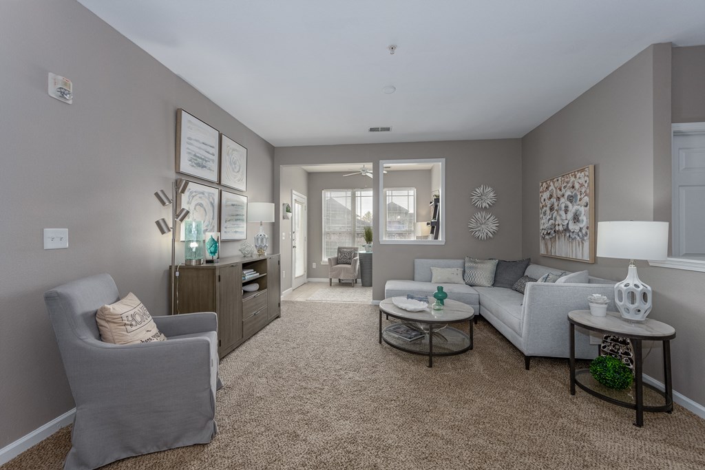 Pet-Friendly Apartments in Florence, KY - Trellises - Furnished Living Room with Wall Art, Sofa, Armchair, Round Coffee Table, Side Table, Lamps, and Carpet Flooring