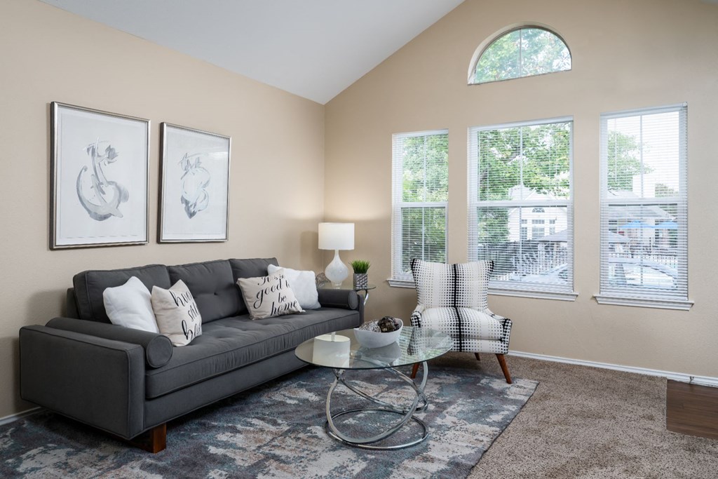 2 BR Apartments in Florence KY - Windridge Townhomes - Living Room with Carpet Flooring, Area Rug, Sofa, Chair, Coffee Table, End Table, Lamp, and Windows