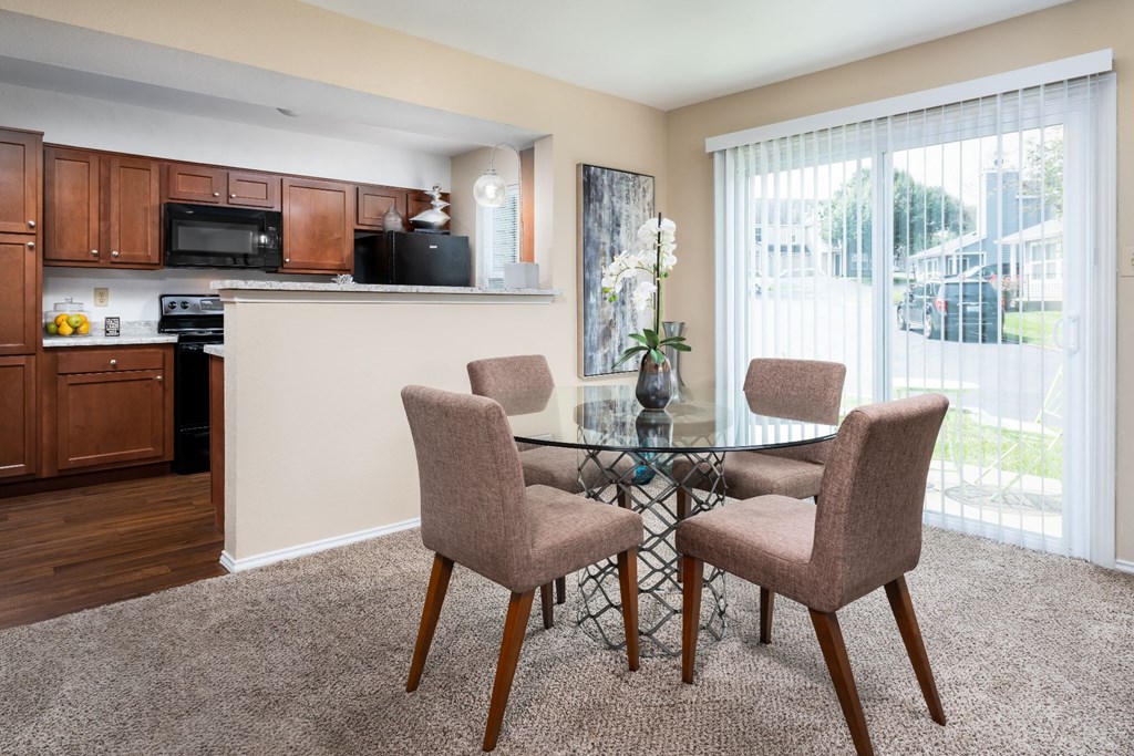a dining area with a glass table and four chairs