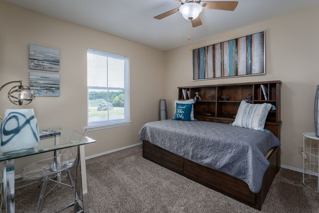 a bedroom with a bed and a desk with a chair